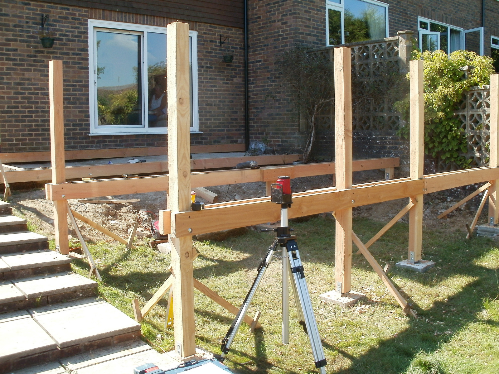 Basic layout of beams and posts, sitting on concreted metal post bases.